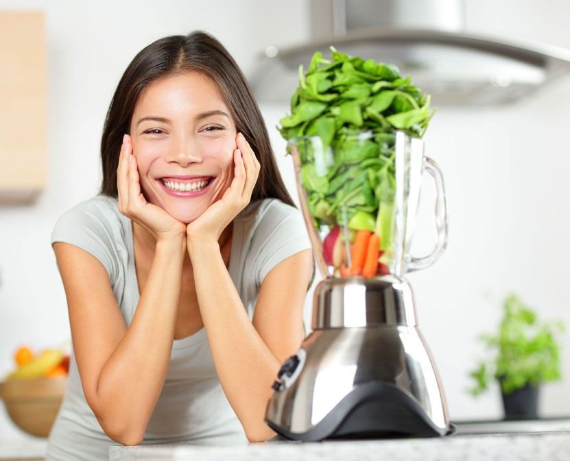 Person Smiling with Vegetables in Blender